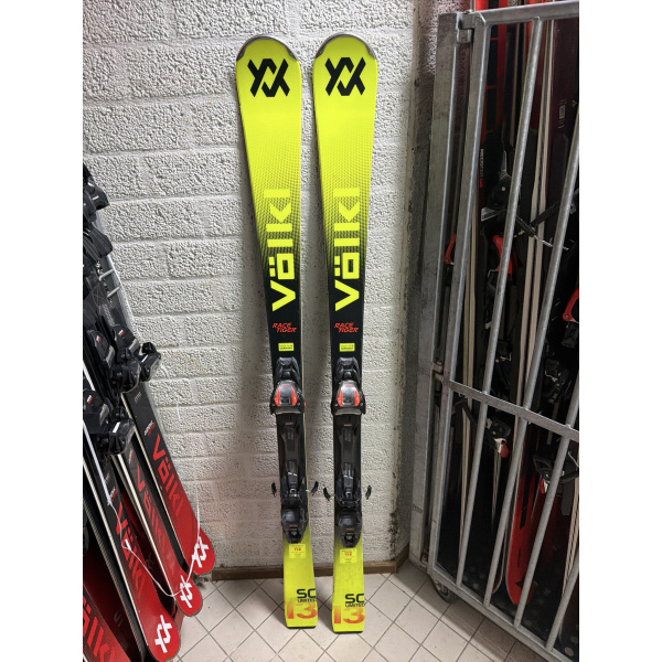 Völkl Racetiger SC Limited von oben: neongelbe Ski mit schwarzem Völkl-Logo und Bindung vor einer weißen Backsteinwand